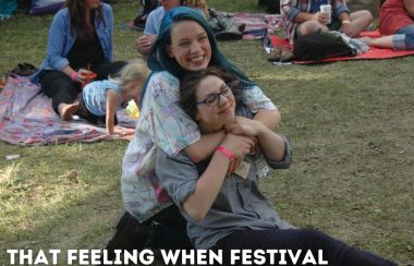 Two people hug outside at a music festival