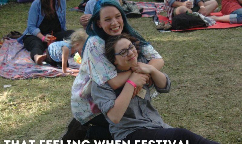 Two people hug outside at a music festival