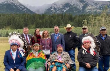 Chiefs and government officials sit in front a mountain that was renamed officially on Monday.