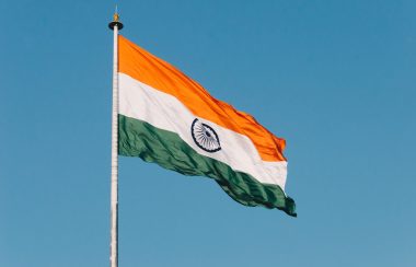 The Indian flag flies against a clear blue sky
