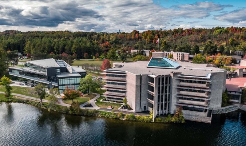An aerial view of Trent University, showing the Otonabee River, Bata Library, and the Student Centre.