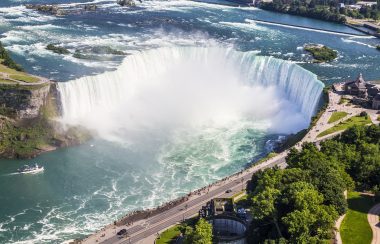 an overhead view of Niagara Falls. A street filled with people is on the right.