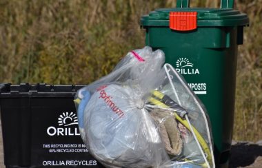 Bacs de recyclage noir et vert et un sac à ordures transparant à l'éfigie de la ville d'Orillia