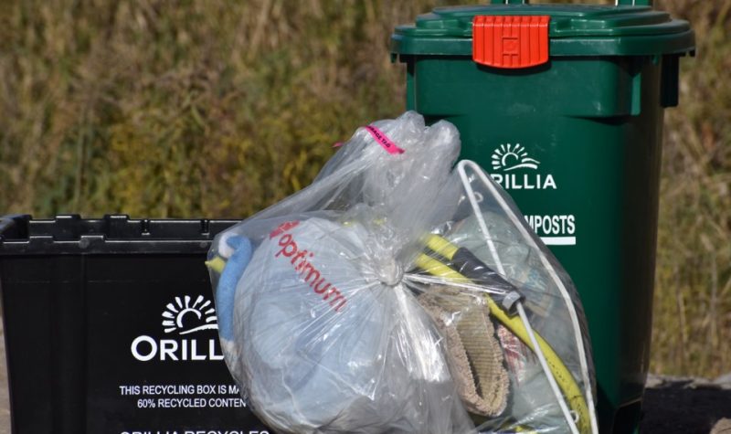 Bacs de recyclage noir et vert et un sac à ordures transparant à l'éfigie de la ville d'Orillia