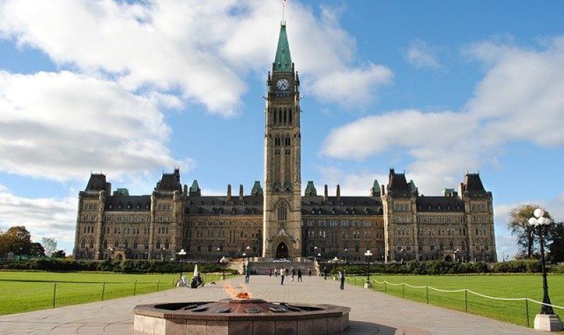 Parlement d'Ottawa vu d'en face avec la flamme qui brûle devant l'entrée