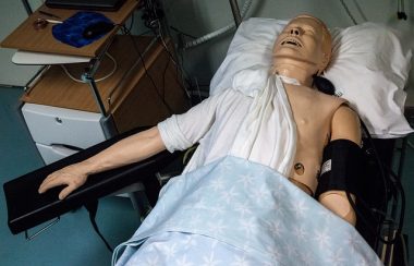 Une poupée d'ambulancier et couchée sur un lit d'infirmerie.