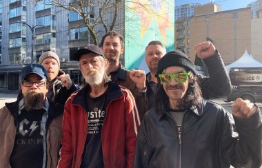 A group of Downtown Eastside harm reduction peer support workers standing together outside.