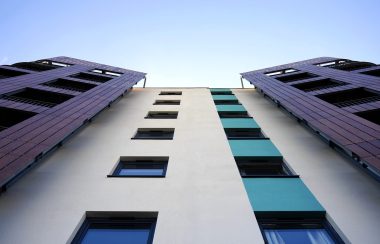 Stock photo of a tall apartment building, looking up at it.