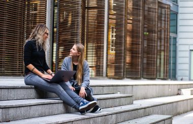 Deux étudiantes conversent sur des escaliers