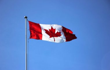 le drapeau du Canada flottant devant un ciel bleu