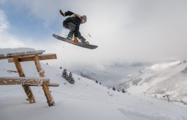 a snowboarder performs a jump when photo is taken mid-air