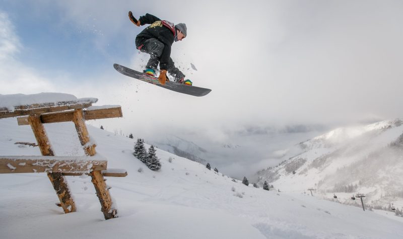 a snowboarder performs a jump when photo is taken mid-air