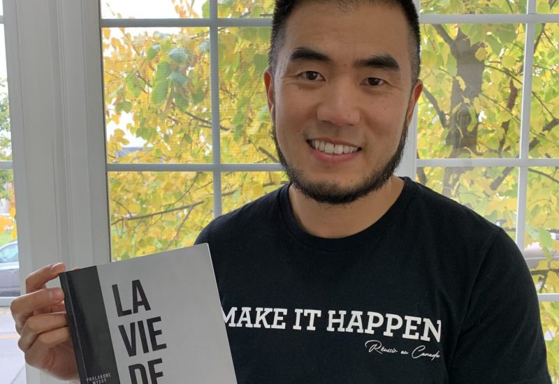 homme asiatique assis avec un livre à la main