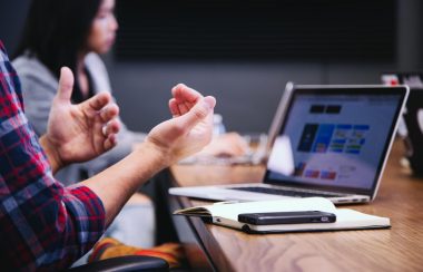 Une personne parlant devant un écran d'ordinateur