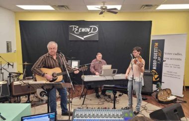 Deux hommes et une femme jouent de al musique dans un studio.