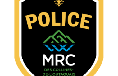 The logo of the MRC des Collines Police, with gold letters on a black background above a logo of green and blue mountains.