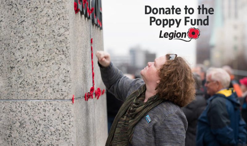 A woman looks up at a stone wall in a promotional poster for the Royal Canadian Legion Poppy Fund.