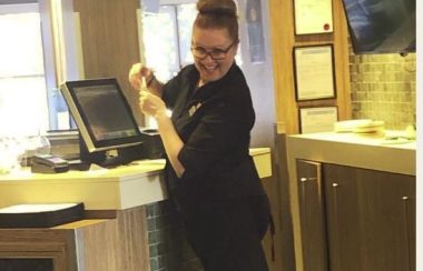 Marcia Little stands at the cashier at a hotel in Nanaimo