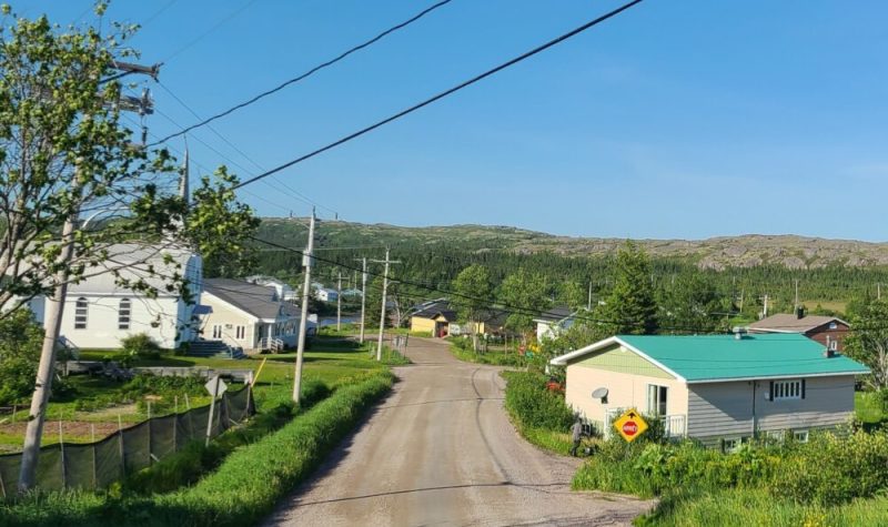 Une route qui s'élonge au loin traverse un village de la Basse-Côte-Nord.