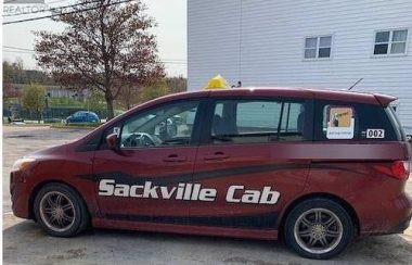 A photo of a red cab with Sackville Cab branded on side.