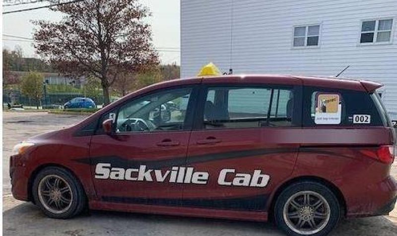 A photo of a red cab with Sackville Cab branded on side.