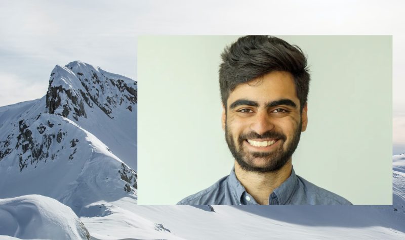 staff writer salmaan farooqui portrait on top of snow covered bc mountains