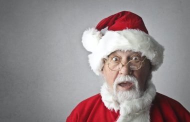 Un père Noël devant un fond gris