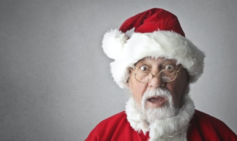 Un père Noël devant un fond gris