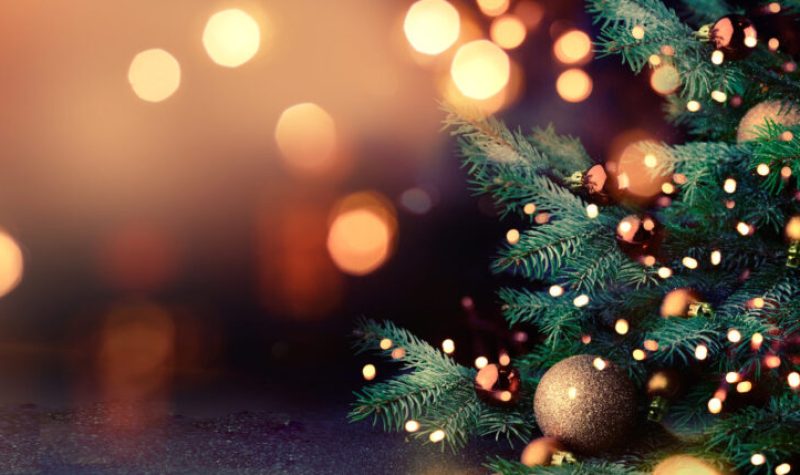 Sapin de Noël avec éclairage doré et décorations dorés. Fond de l'image flou