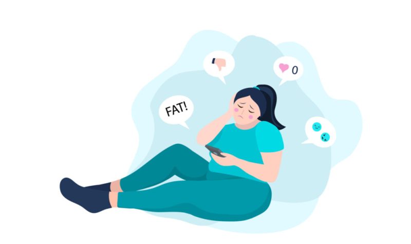 Image dessinée d'une femme assise vêtue de bleu regardant son portable et recevant des message dégradant sur son poids corporel.