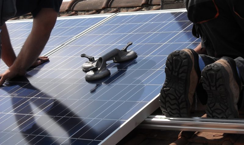 des travailleurs installent des panneaux solaires sur un toit de maison