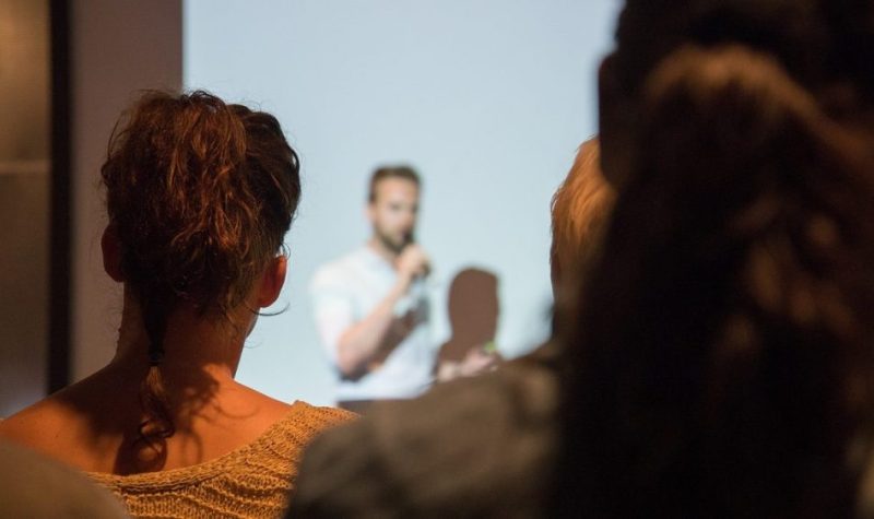 Plan rapproché d'un public qui assiste à une présentation.