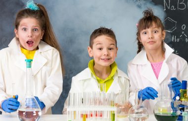 Une photo de trois enfants qui font une expérience scientifique.