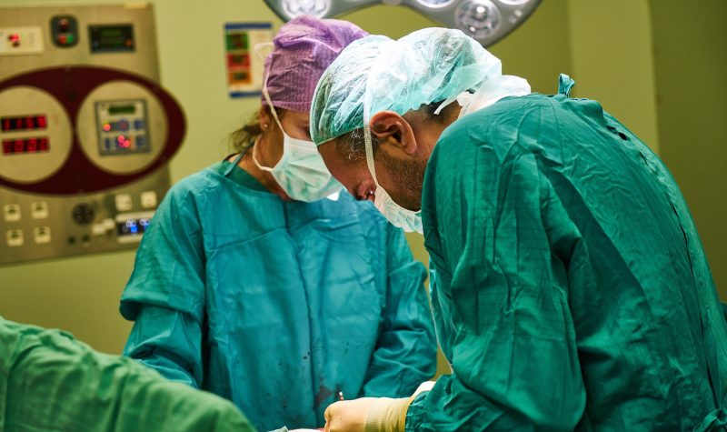 Deux médecins opèrent en bloc opératoire.