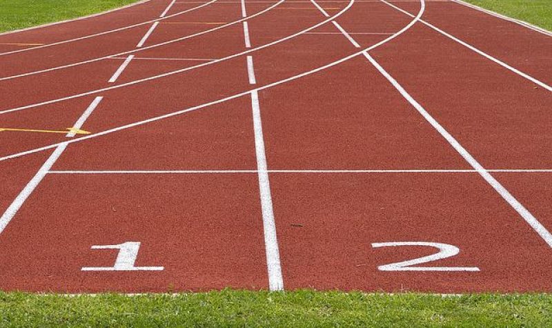 Ligne de départ d'une piste d'athlétisme. On voit le numéro des corridors inscrits en blanc.