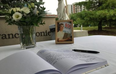 Un table dessus une photo, un cahier et un bouquet de fleur