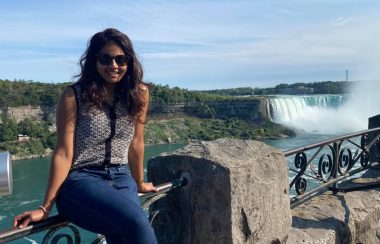 Permanent resident Marushka Loshki Nair sitting on the Niagara Falls railing.