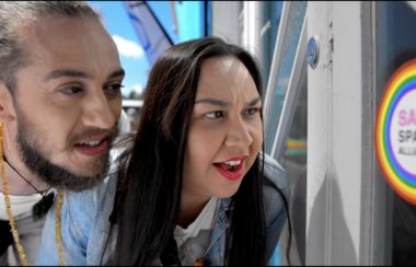 Two people, a man and a woman, starring at sign on door.