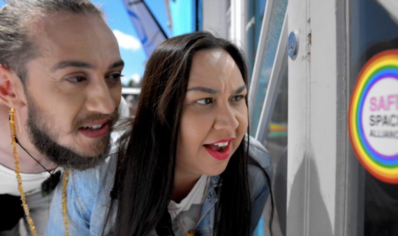 Two people, a man and a woman, starring at sign on door.