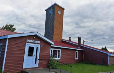 Centre communautaire de Saint-Jean-Baptiste-de-Restigouche. Le bâtiment est rouge est les portes sont blanches