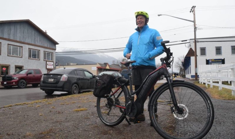 A photo of Tony Harris outside with a bicycle.