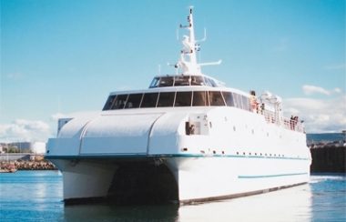 Traversier blanc près d'un quai de pierres et ciel bleu dégagé