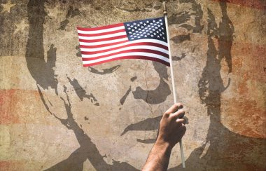 Portrait de Donald Trump derrière un drapeau américain.