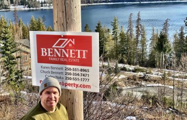 A realtor in front of a sale sign