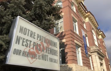 Un enseigne devant l'hotel de ville de Saint-Boniface dit : Notre patrimoine n'est pas à vendre.