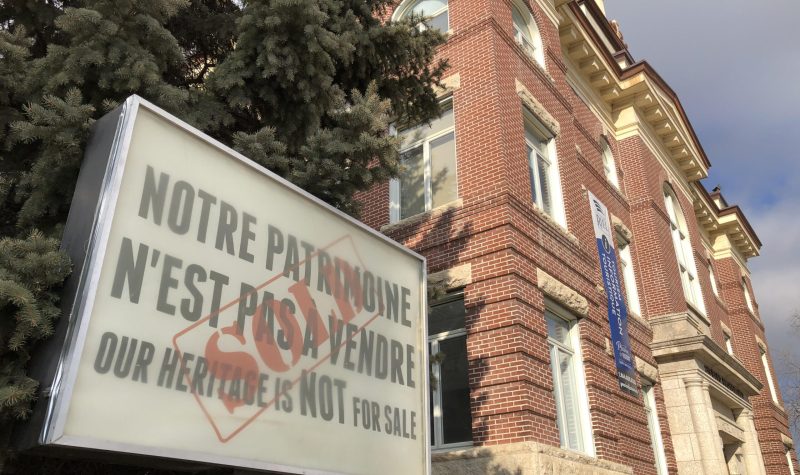 Un enseigne devant l'hotel de ville de Saint-Boniface dit : Notre patrimoine n'est pas à vendre.