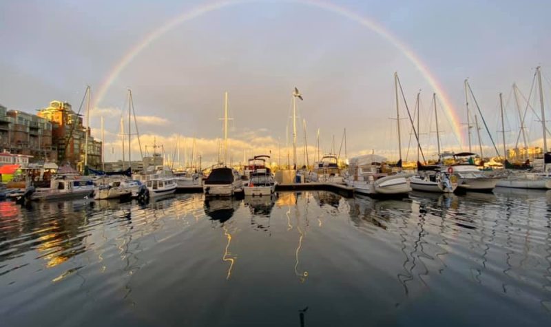 A rainbow is seen overhead at sunset near a pier in Nanaimo.