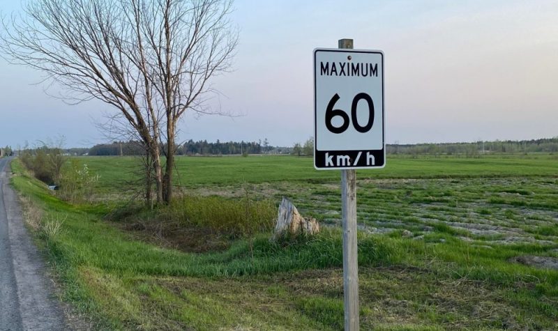Panneau de limite de vitesse indiquant 60 km/h sur une route rural.