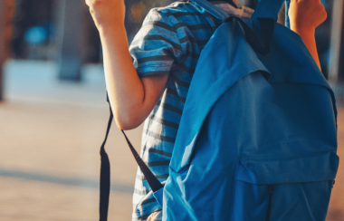 Un niño de espaldas con una mochila azul