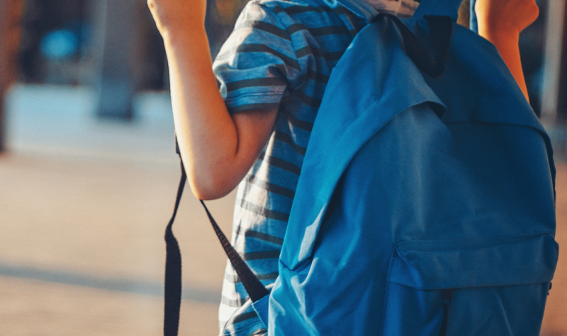 Un niño de espaldas con una mochila azul